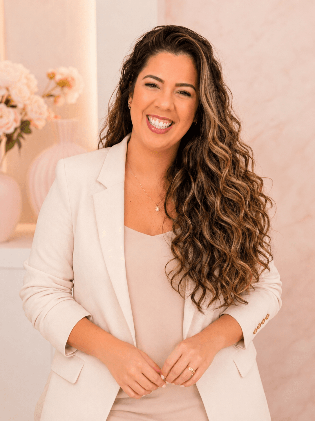 Lais Barbosa, consultora de beleza Mary Kay, em pé em ambiente claro.